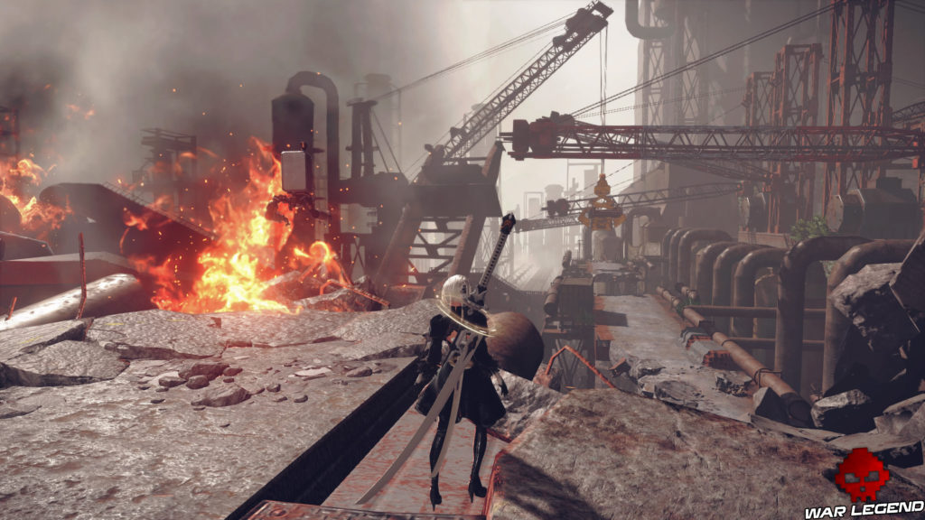 Aperçu NieR Automata héroïne devant paysage industriel, flammes sur sa gauche