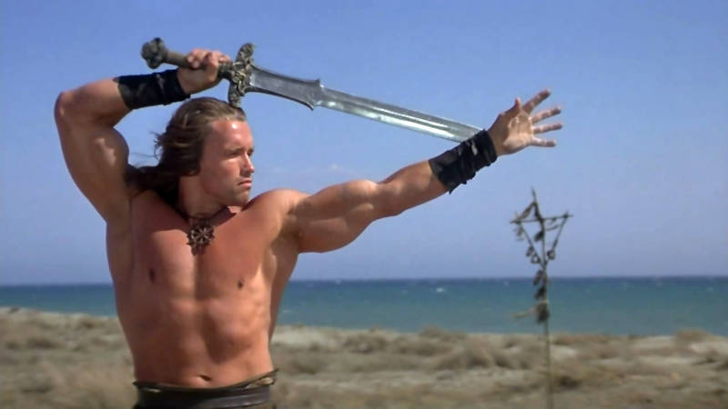 arnold schwarzenegger dans le rôle de Conan le Barbare, maniant l'épée atlante