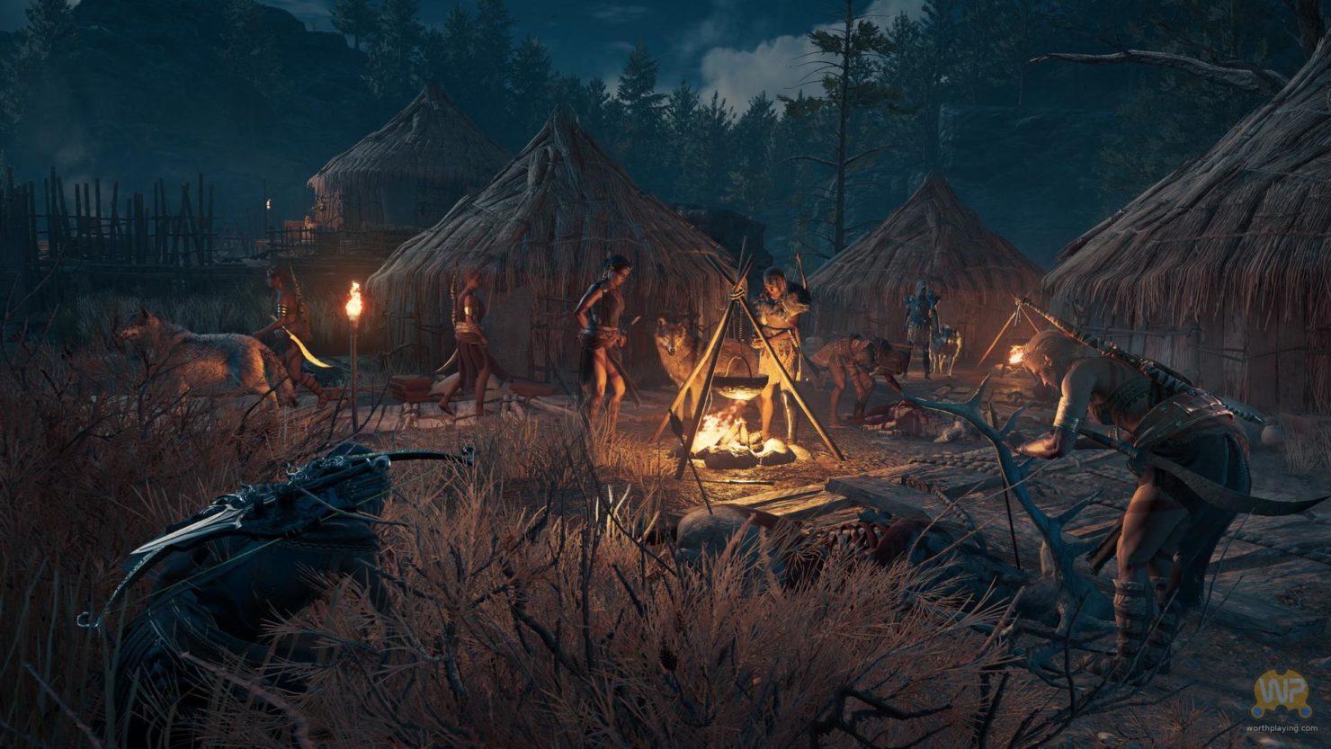 Assassin's Creed Odyssey assassin accroupi dans les hautes herbe à la nuit tombée, dans un camp d'ennemis