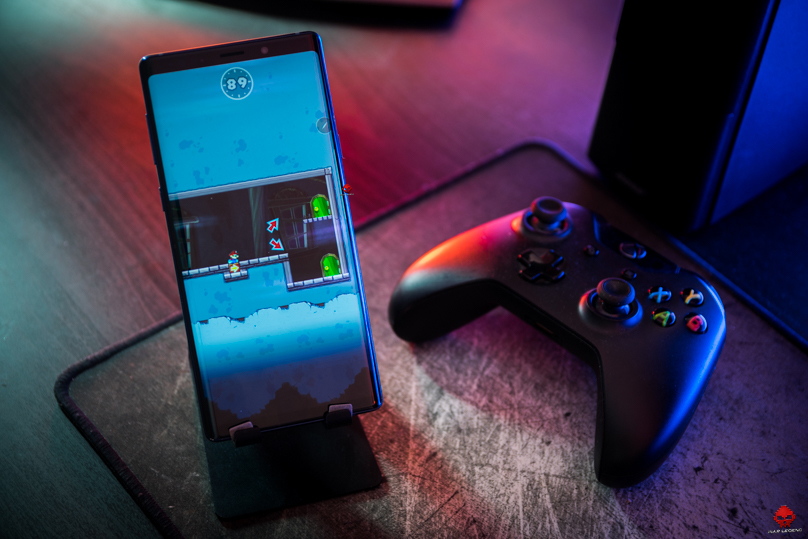 samsung galaxy note 9 sur stand à l'horizontal à côté d'une manette xbox