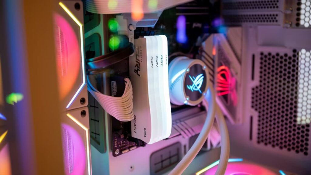 Interieur d un PC gamer en cours de montage montrant une barrette de RAM Kingston Fury DDR4 et un bloc watercooling RGB signe ROG Asus